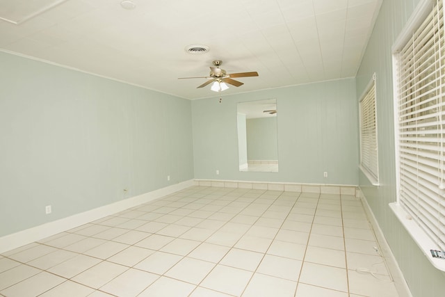 tiled spare room featuring crown molding and ceiling fan