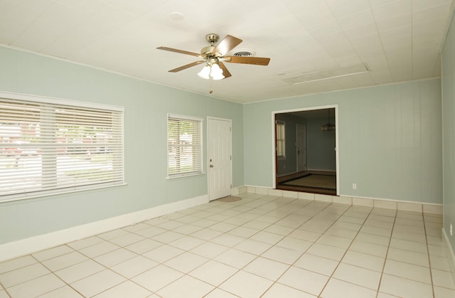 spare room featuring light tile patterned floors, crown molding, and ceiling fan