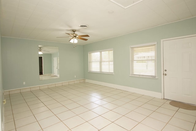 unfurnished room with ornamental molding, ceiling fan, and light tile patterned flooring