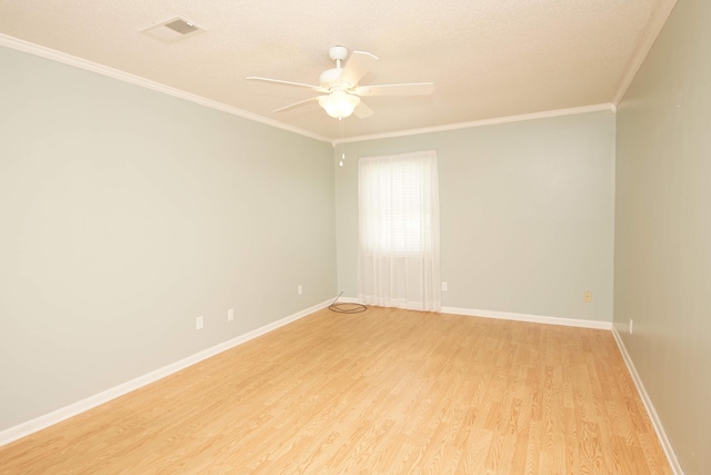 empty room with ceiling fan, visible vents, baseboards, light wood-style floors, and crown molding