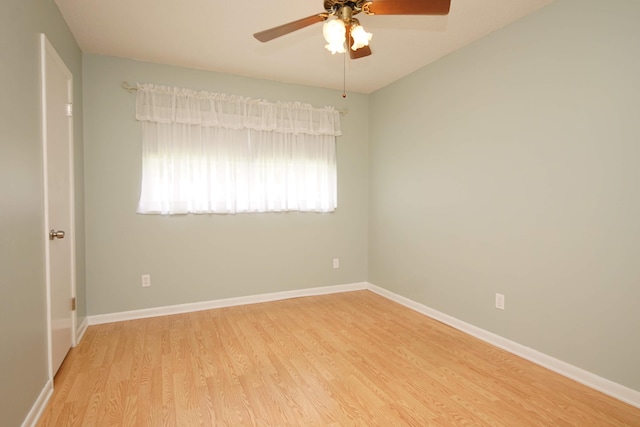 empty room featuring light wood-style floors, ceiling fan, and baseboards