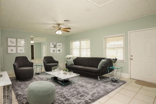 living room with crown molding, light tile patterned flooring, and ceiling fan