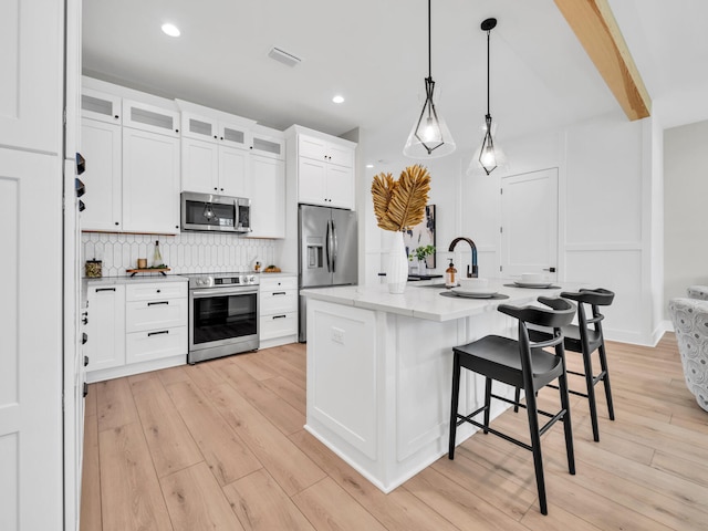 140 Sibert Ave Unit 16, Destin, FL 32541 - kitchen with stainless steel appliances, tasteful backsplash, light wood-style flooring, a breakfast bar, and recessed lighting