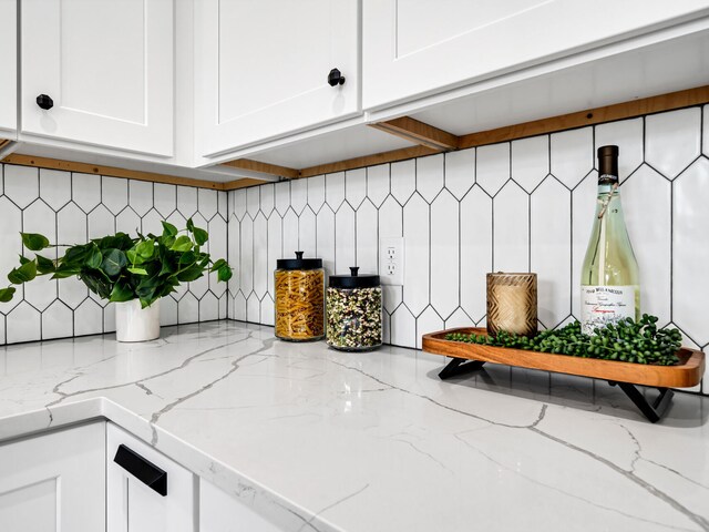 140 Sibert Ave Unit 16, Destin, FL 32541 - kitchen view of white cabinetry, tasteful backsplash, and light stone counters