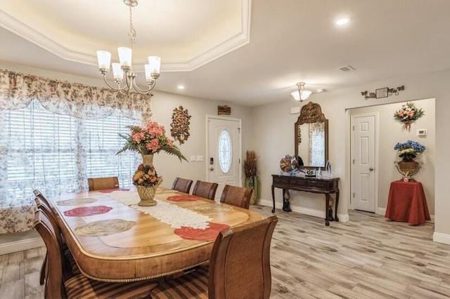 dining area featuring plenty of natural light, light hardwood / wood-style flooring, and a tray ceiling