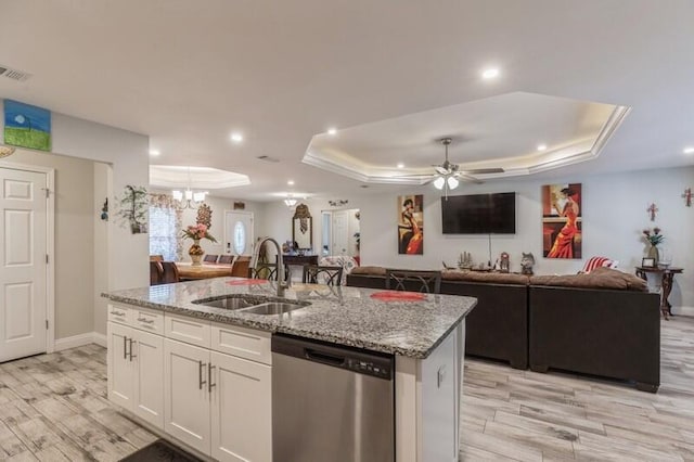 kitchen with white cabinetry, dishwasher, ceiling fan with notable chandelier, a raised ceiling, and sink