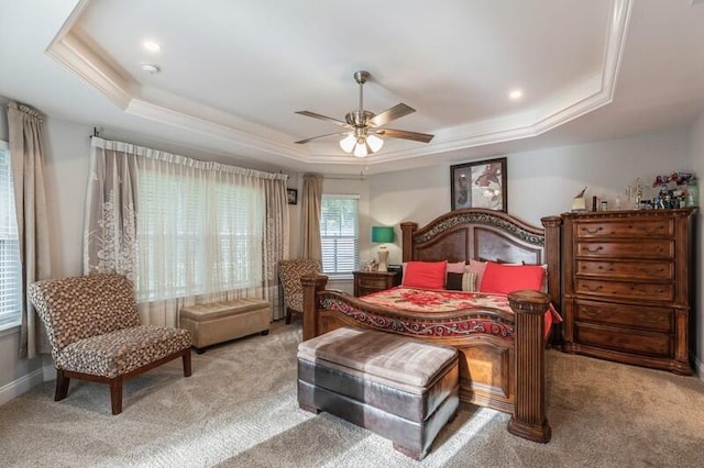 carpeted bedroom featuring a raised ceiling and ceiling fan