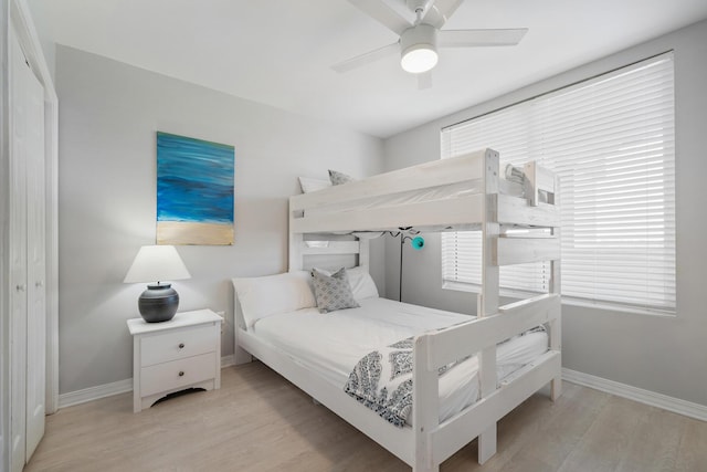 bedroom with ceiling fan, light hardwood / wood-style flooring, and a closet