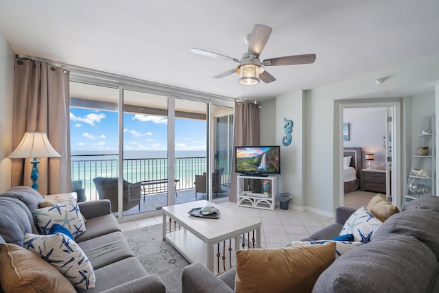 tiled living room with floor to ceiling windows and ceiling fan