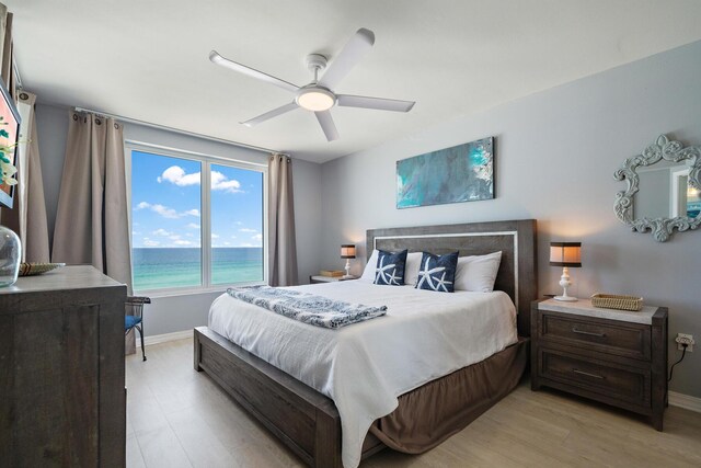 bedroom featuring a water view, ceiling fan, and light hardwood / wood-style floors