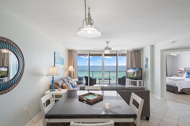 tiled living room featuring ceiling fan and floor to ceiling windows