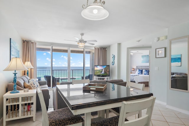 tiled dining room featuring a wall of windows and ceiling fan