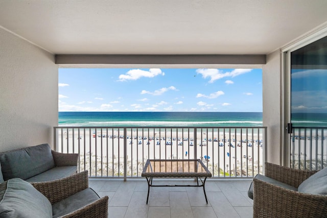 balcony featuring a view of the beach and a water view