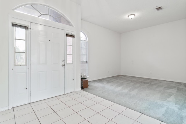 entryway with light carpet and a textured ceiling