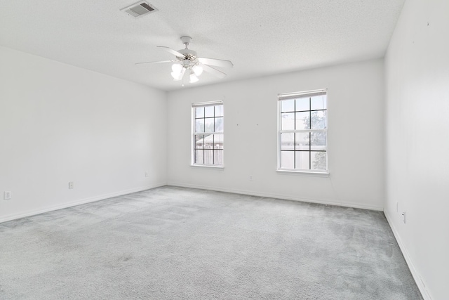 carpeted empty room with a textured ceiling and ceiling fan