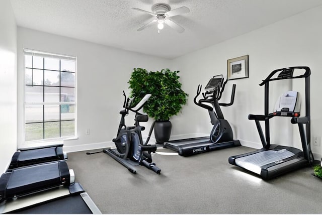 workout area with ceiling fan and a textured ceiling