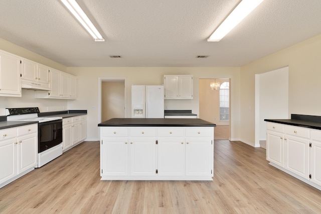 kitchen featuring electric stove, dark countertops, white cabinetry, white fridge with ice dispenser, and under cabinet range hood