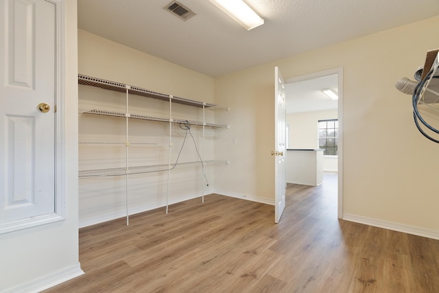 spacious closet featuring visible vents and wood finished floors