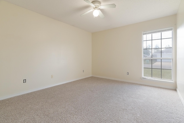 spare room with ceiling fan, baseboards, and carpet flooring