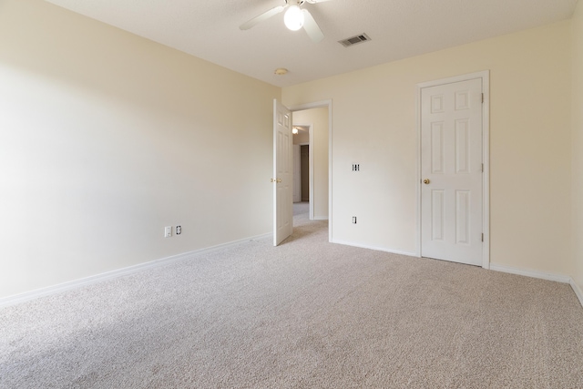 unfurnished bedroom featuring baseboards, a ceiling fan, visible vents, and light colored carpet