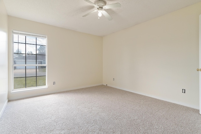 carpeted empty room with a textured ceiling, baseboards, and a ceiling fan