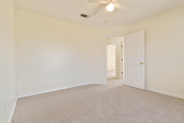 unfurnished room with baseboards, visible vents, ceiling fan, and light colored carpet