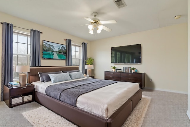 bedroom featuring light colored carpet, visible vents, ceiling fan, and baseboards