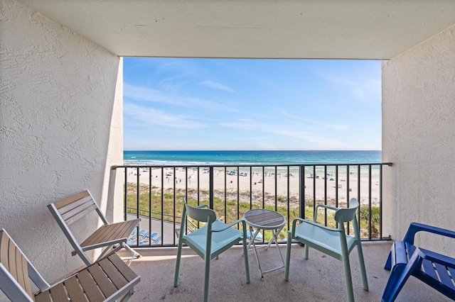 balcony featuring a water view and a view of the beach