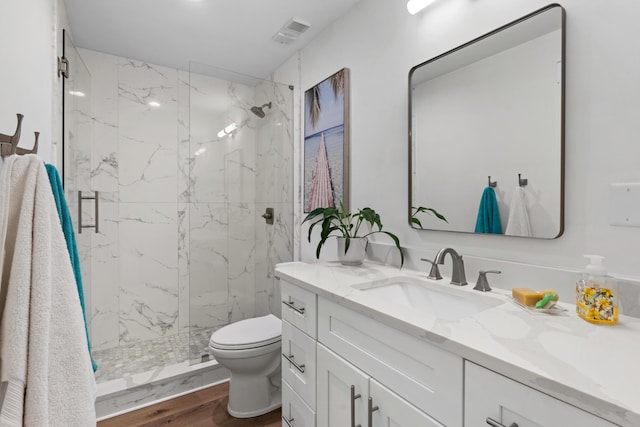 bathroom featuring toilet, vanity, walk in shower, and hardwood / wood-style floors