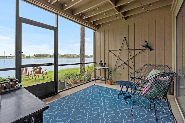 sunroom featuring a water view