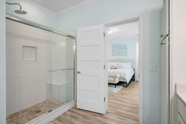 bathroom with hardwood / wood-style flooring, crown molding, and a shower with door