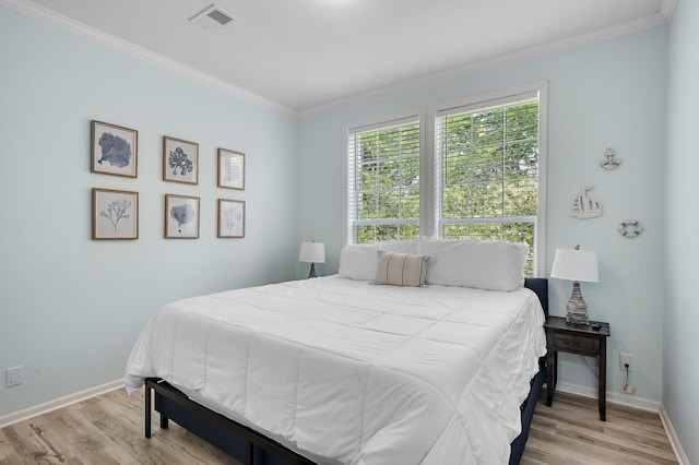 bedroom featuring light wood-type flooring and ornamental molding