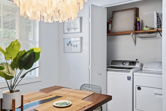 laundry room with a chandelier, laundry area, washer and dryer, and plenty of natural light