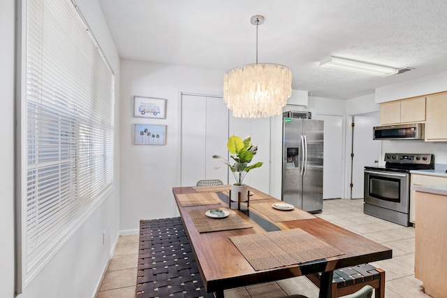 dining room featuring light tile patterned floors, visible vents, a textured ceiling, and an inviting chandelier