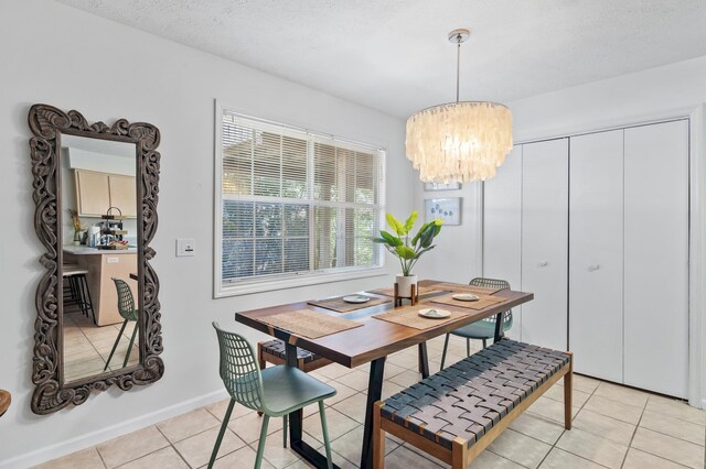 dining area with a notable chandelier, light tile patterned floors, and a textured ceiling