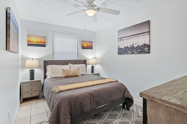 bedroom with light tile patterned floors, a textured ceiling, and ceiling fan