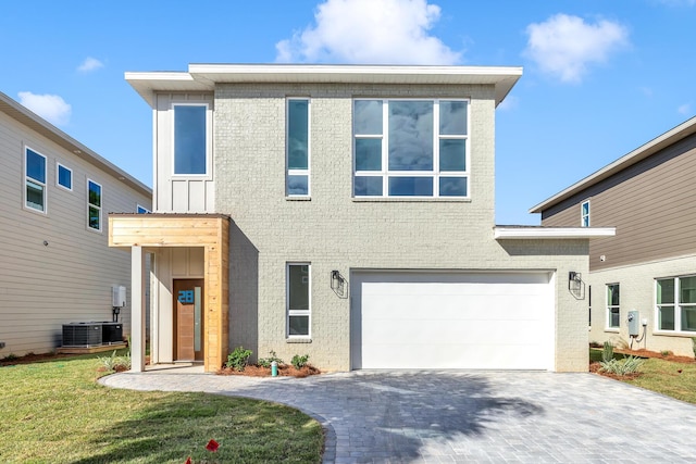 view of front facade featuring a front lawn, cooling unit, and a garage