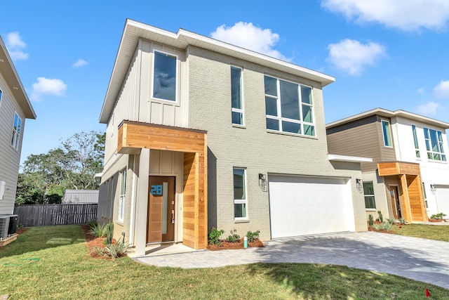 modern home featuring a garage and a front lawn