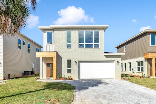 view of front of home featuring central air condition unit, a front lawn, and a garage