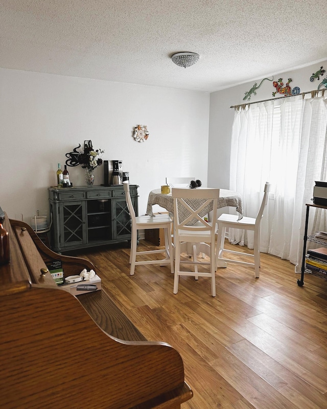 dining room featuring hardwood / wood-style floors and a textured ceiling