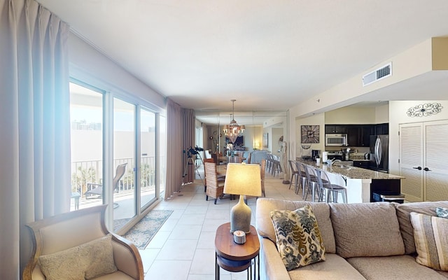 living room featuring light tile patterned floors and a chandelier