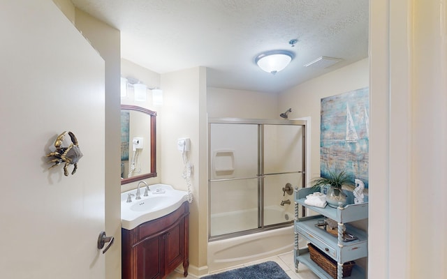 bathroom with vanity, a textured ceiling, tile patterned floors, and bath / shower combo with glass door