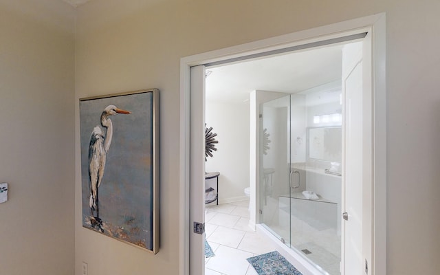 bathroom featuring an enclosed shower, tile patterned flooring, and toilet