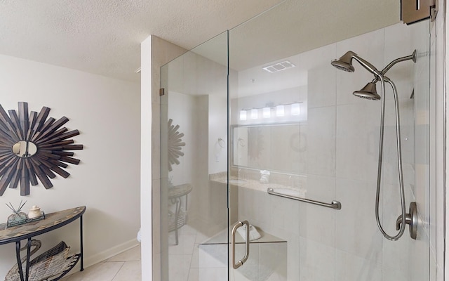 bathroom with tile patterned flooring, a shower with door, and a textured ceiling