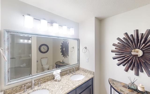 bathroom with vanity, a textured ceiling, and toilet