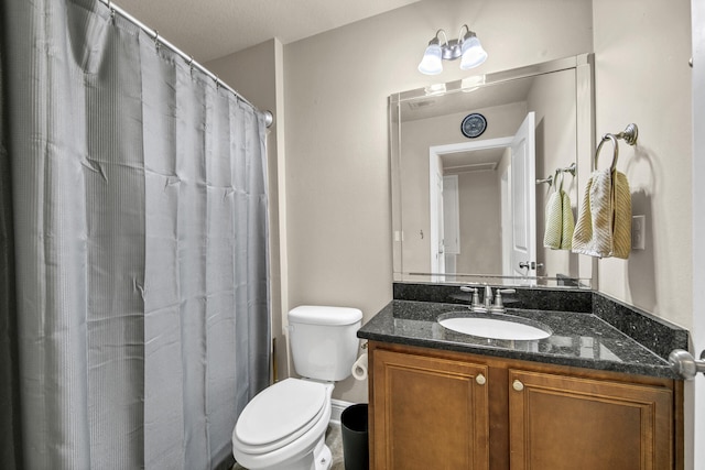 bathroom featuring walk in shower, vanity, toilet, and a textured ceiling