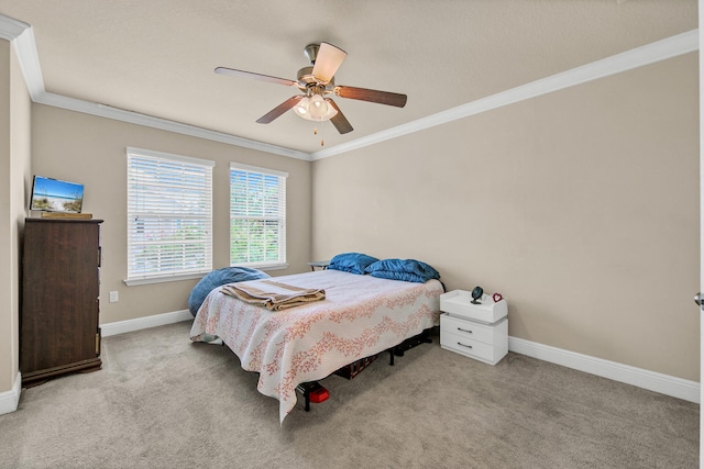 carpeted bedroom with ornamental molding and ceiling fan