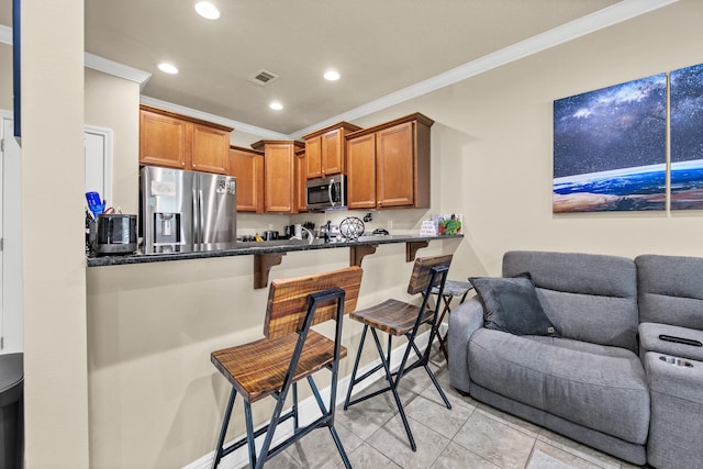 kitchen with crown molding, a breakfast bar area, stainless steel appliances, and kitchen peninsula