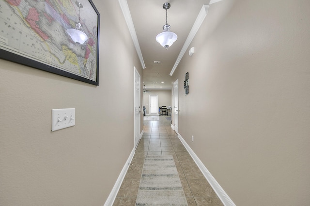 hallway featuring ornamental molding and light tile patterned floors