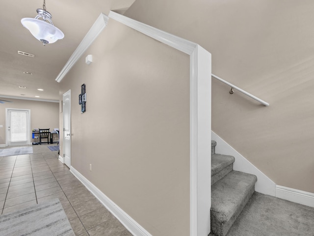 hallway featuring light tile patterned flooring and crown molding